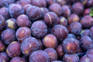 juicy purple plums on the counter of a market