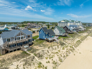 Obraz premium Aerial view of colorful beach front vacation rental properties in the outer banks with beach access, pool, patio, prime American vacation destination