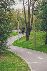 Wnding bike path in the park. Family walking.