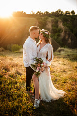 Newlyweds hugging, newlyweds hugging, bride and groom, romantic married couple at sunset holding hands, beautiful couple in the sun, they hug each other, wedding, kissing couple