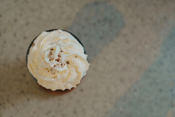 Iced Chocolate with Whipped Cream in a glass. Bokeh and concrete background.