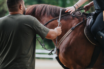 Close-up of a rider receiving instruction while horseback riding outdoors at a ranch, highlighting...