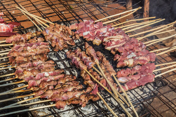Skewers being grilled at a street food stall in Uganda