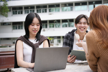 Group of asian students are studying together using laptop and discussing about their project in university
