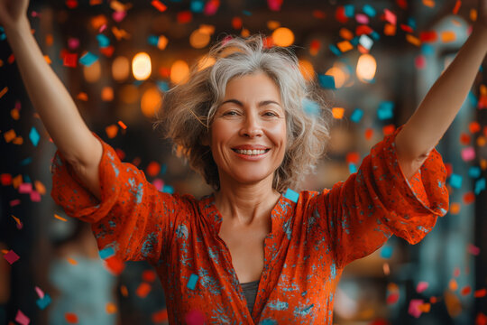 Joyful elderly woman celebrating with confetti. Displaying happiness and celebration. Ideal for marketing, advertisements, and articles focused on positive aging and joyful events.