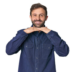 Studio portrait of young Hispanic male keeps hands under chin, is looking happily aside.