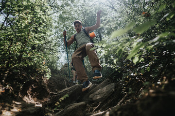 Obraz premium A young man enjoys a summer hike in a forest, navigating rocky terrain with poles on a sunny day. Concept of adventure and exploration.