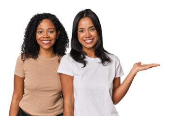 Young Latin friends in studio showing a copy space on a palm and holding another hand on waist.