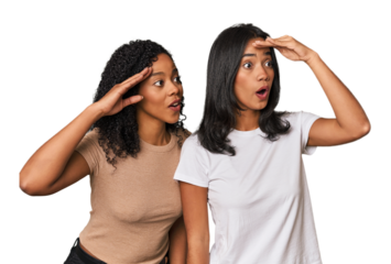Young Latin friends in studio looking far away keeping hand on forehead.