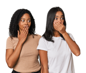 Young Latin friends in studio thoughtful looking to a copy space covering mouth with hand.