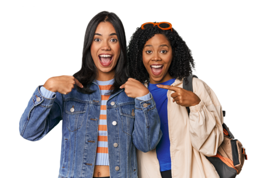 Latin friends ready for vacation surprised pointing with finger, smiling broadly.