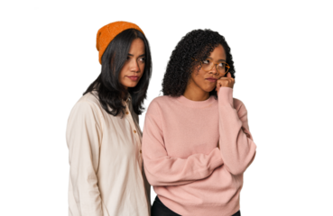 Young Latin friends together in studio who feels sad and pensive, looking at copy space.