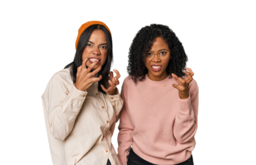 Young Latin friends together in studio upset screaming with tense hands.