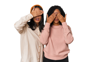 Young Latin friends together in studio afraid covering eyes with hands.