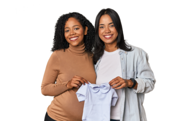Two Latin women, one pregnant, with baby's bodysuit in studio