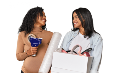 Two Latin women, one pregnant, with moving box in studio