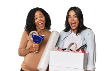 Two Latin women, one pregnant, with moving box in studio