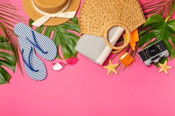 Beach accessories. Beach bag with hat, beach towel, sunglasses, spf cream and sandals on bright...