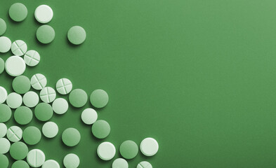 Medical pills. On a green background. Top view.