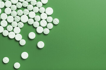 Medical pills. On a green background. Top view.