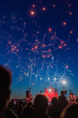 feu d'artifice de nuit face à des personnes regardant un concert 