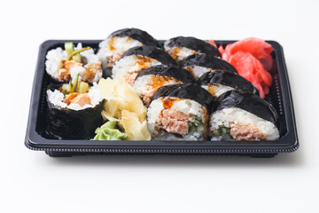 Takeaway sushi background. Salomon sushi roll. Japanese food isolated on white. Sushi box cutout. Red marinated ginger. Futomaki with grilled fish. Healthy lunch idea.