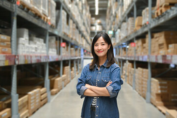 Confident woman standing in a warehouse aisle with shelves filled with boxes and products.