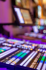 Professional video and sound mixer control panel with buttons and sliders. Inside an outside...