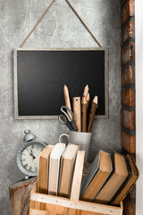 Time for school - blackboard, clock, books and school supplies on bricks background