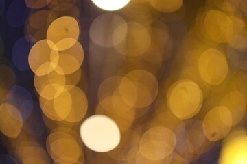 Bokeh, Festive abstract Christmas texture, golden bokeh particles and highlights on dark background.