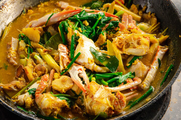 A bowl of food with shrimp and vegetables. The dish is full of color and looks delicious. The shrimp is cooked and the vegetables are fresh and crisp. The dish is served in a black pan
