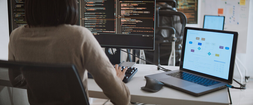 Young adult Asian male, female software developer coding program on desktop computer. Man, woman work from home, remote working, freelance programmer job, smart digital nomad lifestyle concept