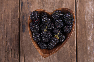 Ripe black blackberries on a wooden table