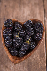 Ripe black blackberries on a wooden table