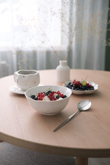 Enjoy a Healthy Breakfast with Yogurt, Fresh Berries, and Tea on a Modern Table Design