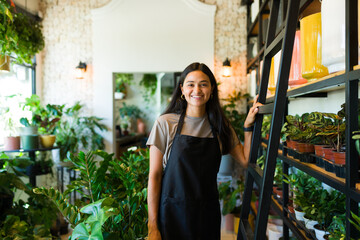 Smiling female plant shop owner surrounded by greenery in her store
