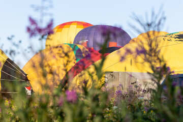 Vivid colorful hot air balloons close up and technician crew preparing for take off