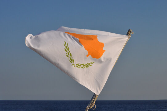 The Cyprus flag on the flagpole in the open blue sea