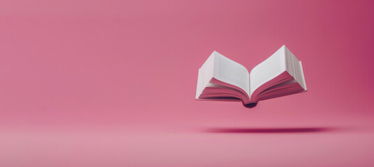 Floating open book against a solid pink background, symbolizing imagination and the endless...