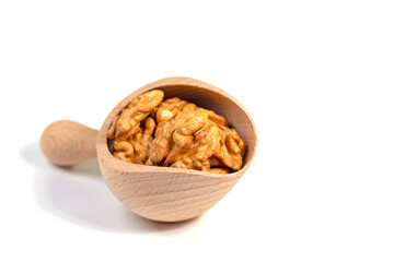 Geknackte Walnüsse in einer Gewürzschaufel vor weißem Hintergrund