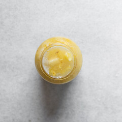 Overhead view of pineapple cheong in a glass jar on a white background, top view of korean pineapple cheong in a transparent jar, pineapple in sugar syrup, process of making pineapple cheong