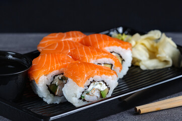 Close-up of sushi rolls in an open plastic container. Natural light, selective focus.