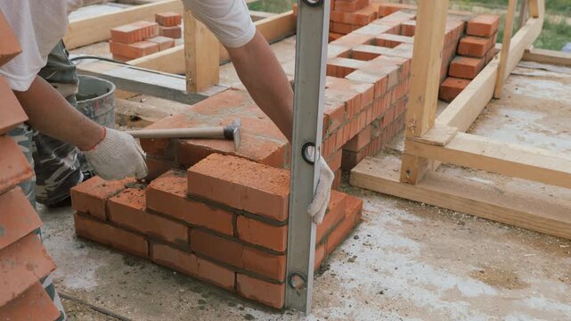 Laying out a brick chimney chimney of a private wooden house.