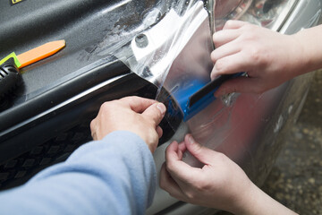 Polishing the old headlight on the car and installing a protective film.