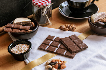 Chocolate chip cookies, dark and white chocolate bar, small bowl of oatmeal and nuts. International Chocolate Day.