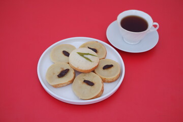 Kue Lumpur or Mud Cake, Indonesian traditional cake made from potato, flour, eggs and coconut milk topped with raisins served on white plate. Selected focus.