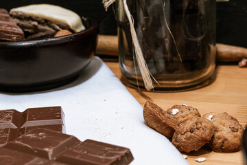 Chocolate chip cookies, dark and white chocolate bar, small bowl of oatmeal and nuts. International Chocolate Day.