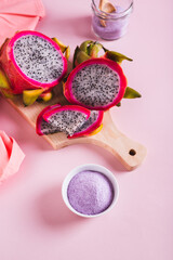Pink matcha powder from dragon fruit in a bowl and jar on the table vertical view