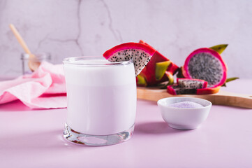 Trendy pink matcha dragon fruit latte in a glass on the table