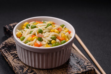 Delicious boiled rice with vegetables or risotto with carrots, peas and corn